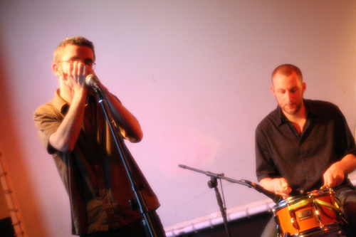 Rob playing harmonica and John drumming.